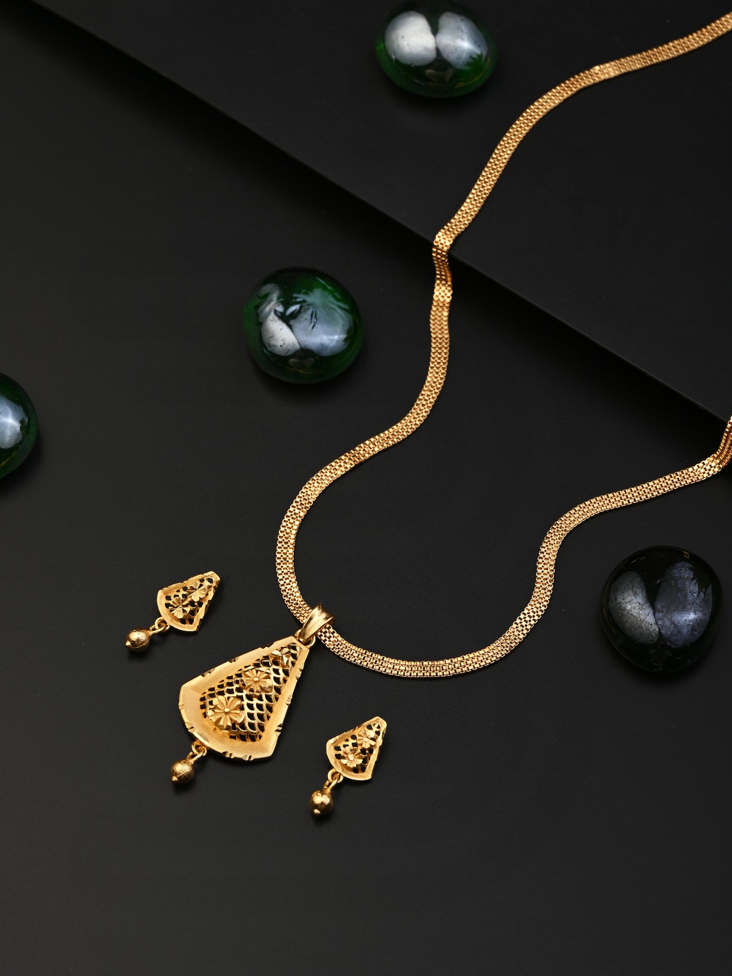 Gold necklace and earrings on a black background